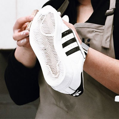 picture of a technician cleaning a sneaker